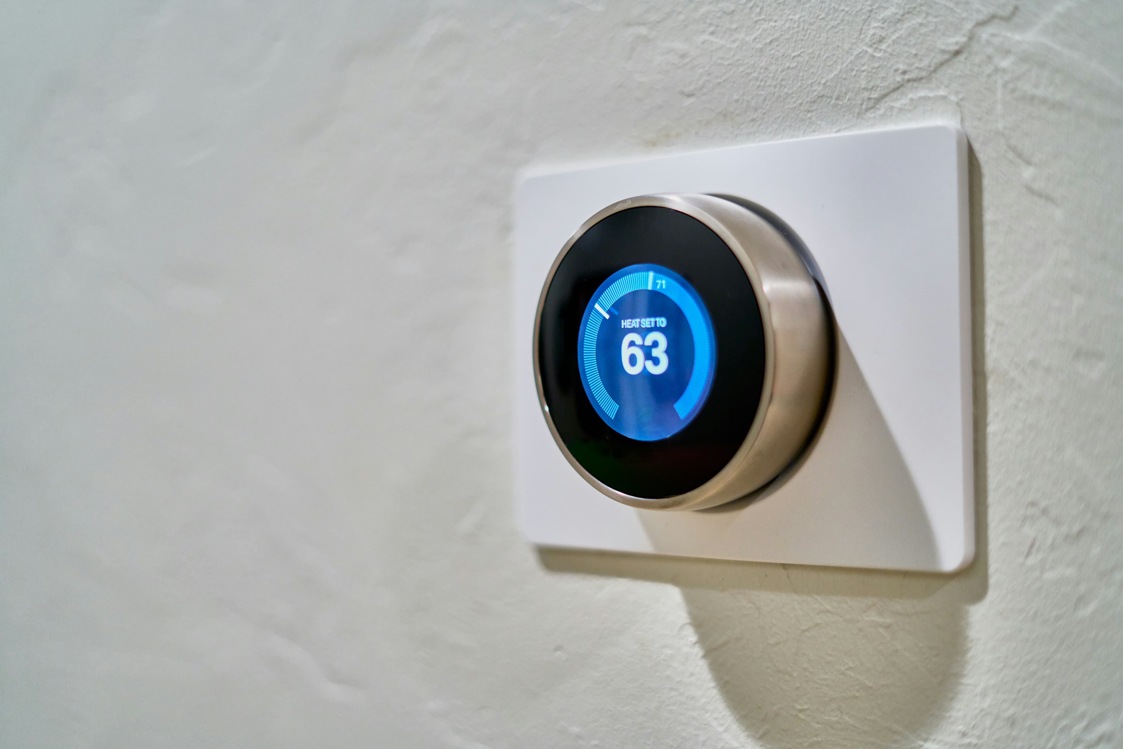 A round wall thermostat showing the room temperature