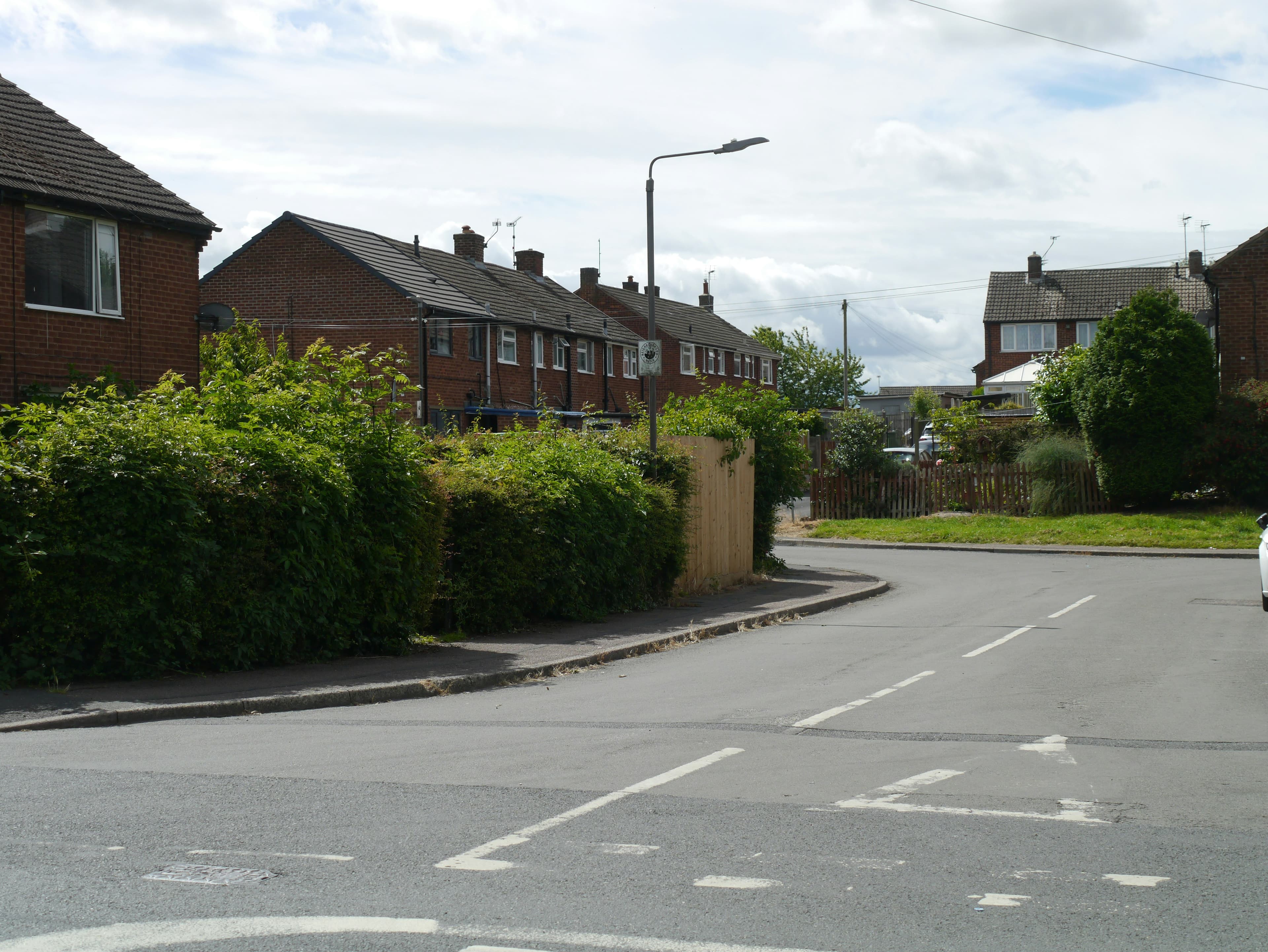 A residential street of houses with front gardens